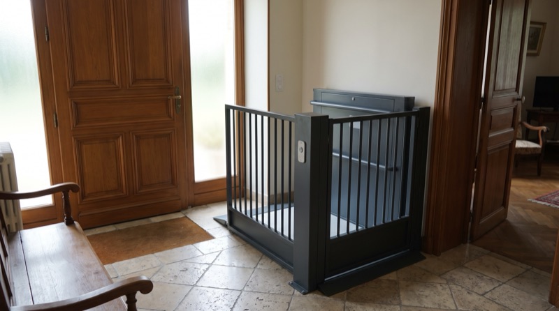 Élévateur PMR à plateforme ouverte installé à l'entrée d'une maison individuelle